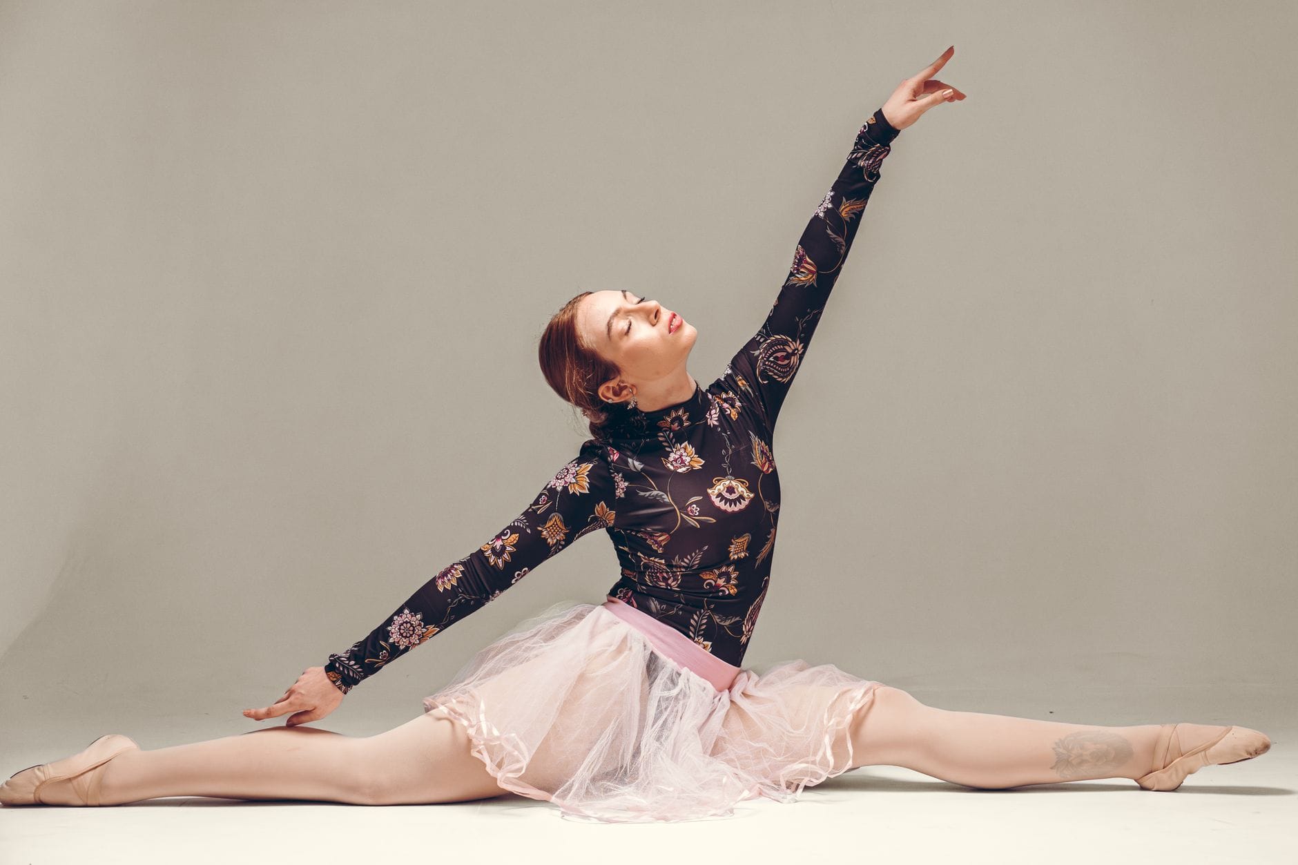 Balerina w studiu prezentuje elegancki szpagat i grację